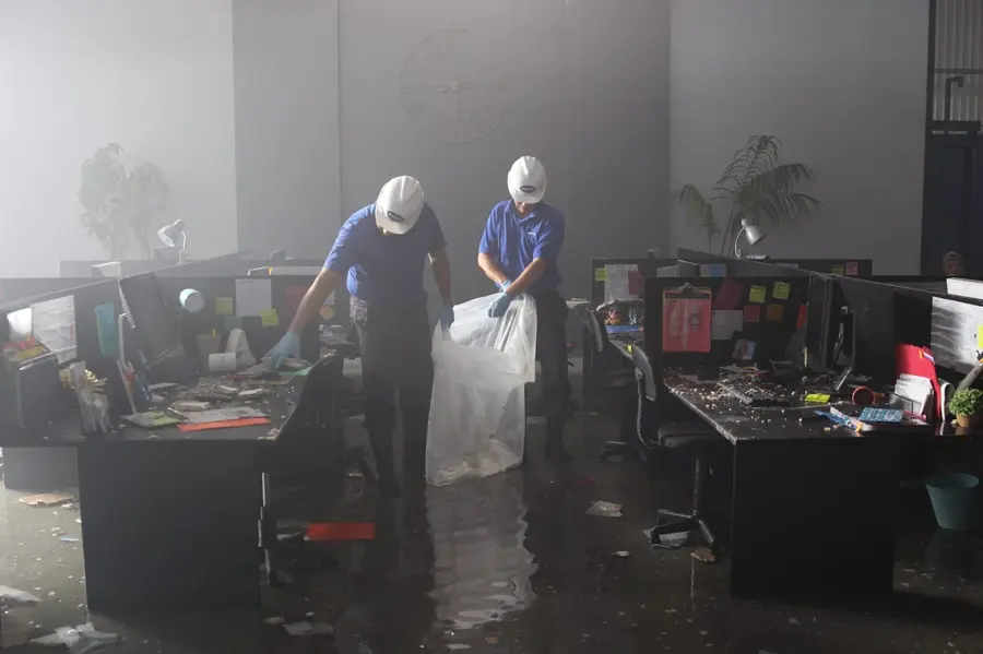 Restoration techs clearing wet materials from a flooded office in Orange County