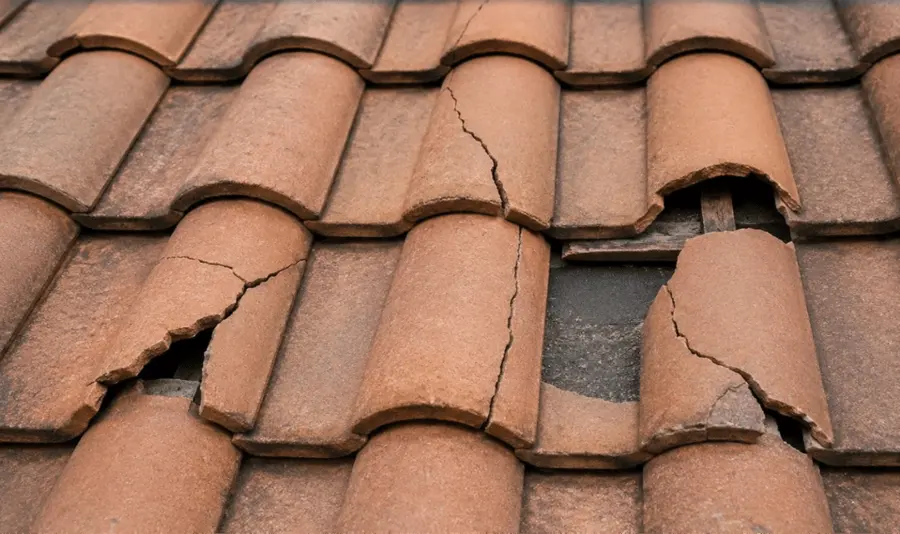 Cracked and broken clay roof tiles that let winter rain reach the underlayment