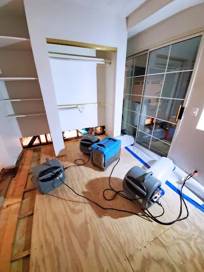 Air movers and a dehumidifier drying exposed subfloor during structural drying in Mission Viejo